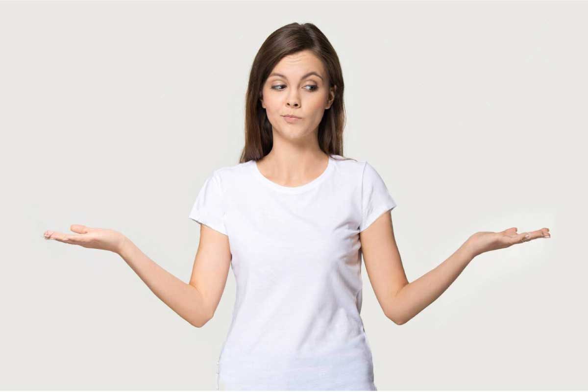 Mujer joven con sus hombros encogidos en señal de desconocimiento.