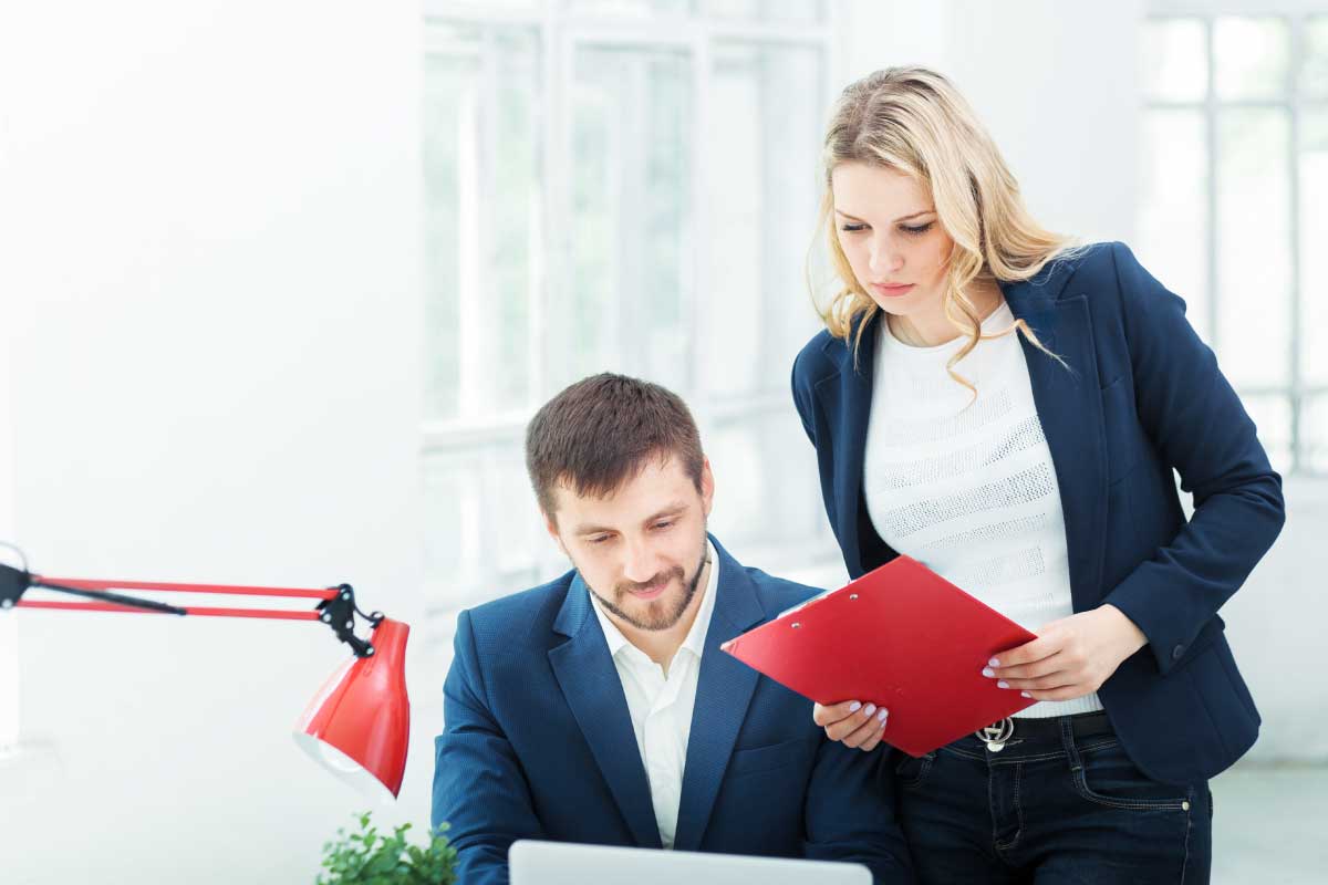 Hombre y mujer de negocios revisando juntos información en un portatil