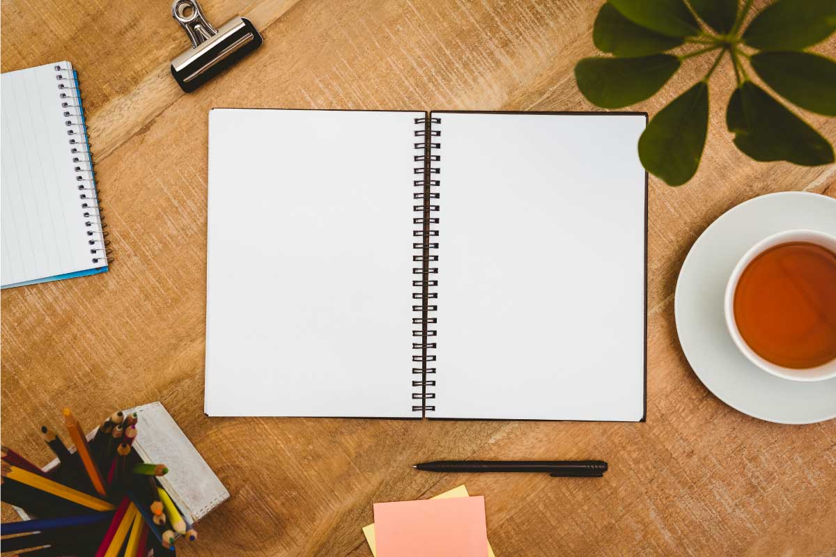 Cuaderno abierto con hojas en blanco sobre una mesa