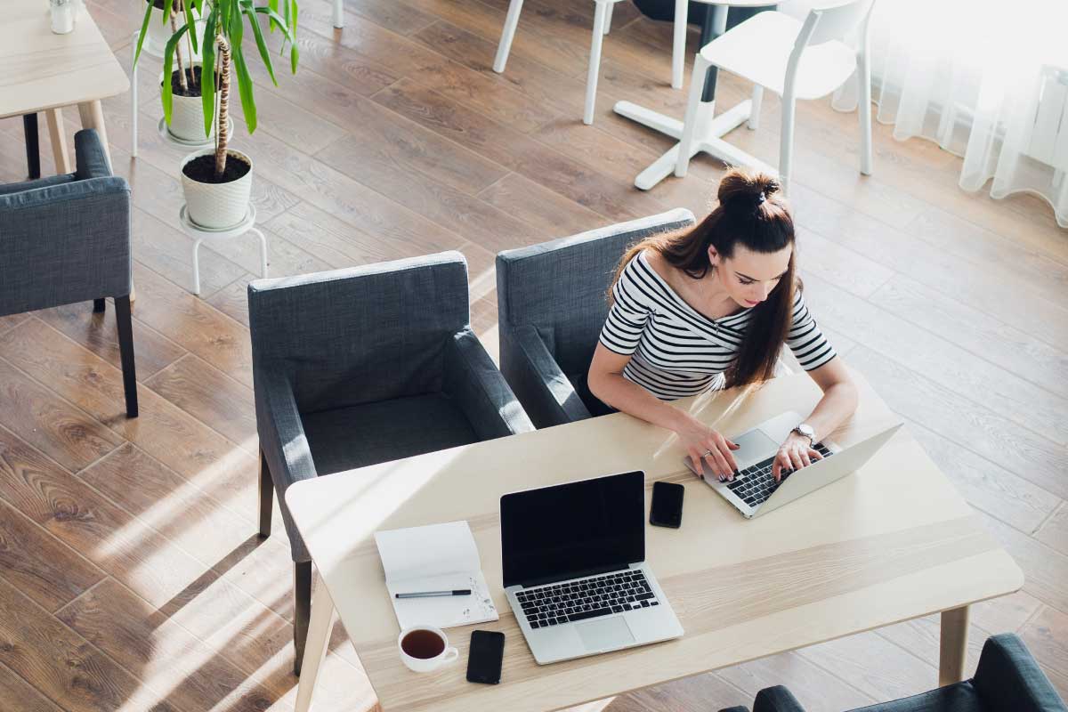 Mujer sentada trabajando en un computador portatil