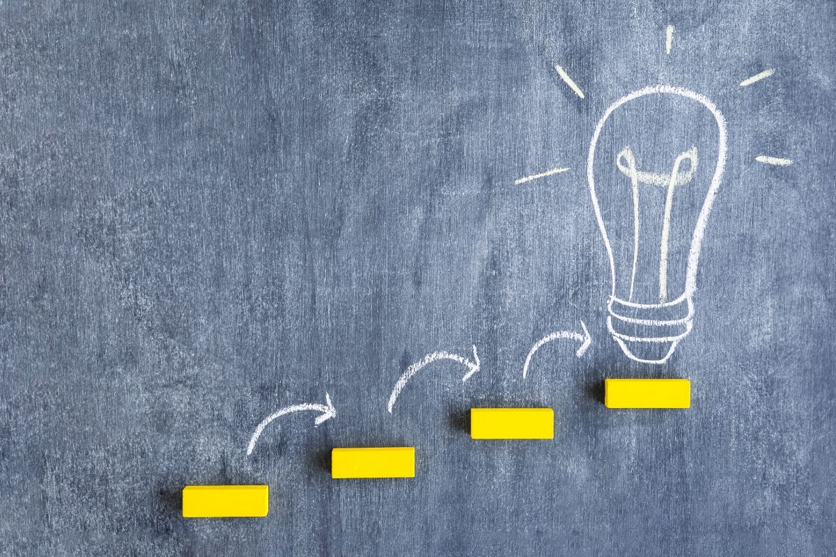 Bombilla dibujada con tiza blanca en un tablero oscuro