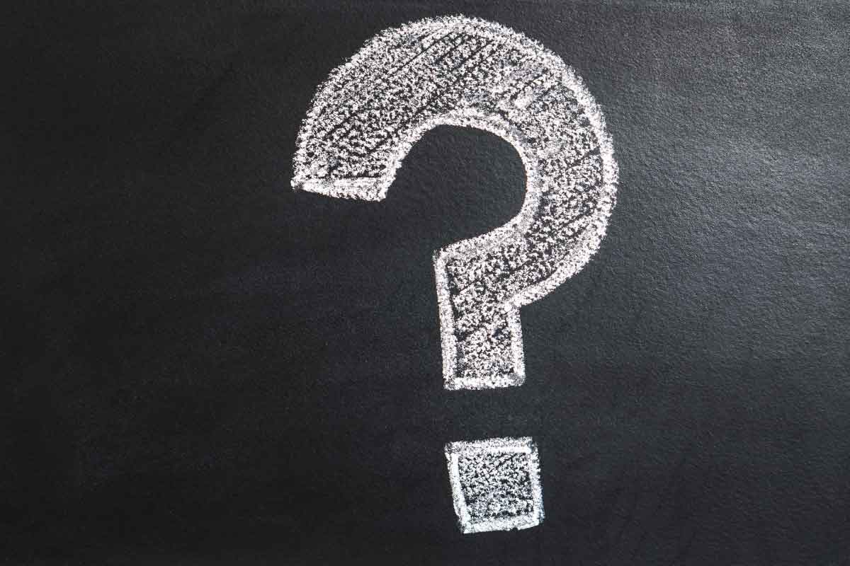 Signo de pregunta dibujado con tiza sobre un fondo negro