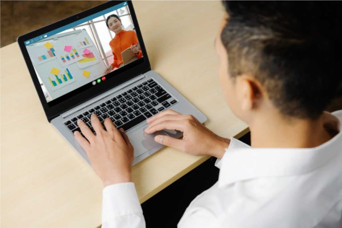 Hombre sentado al frente de un computador en una video llamada