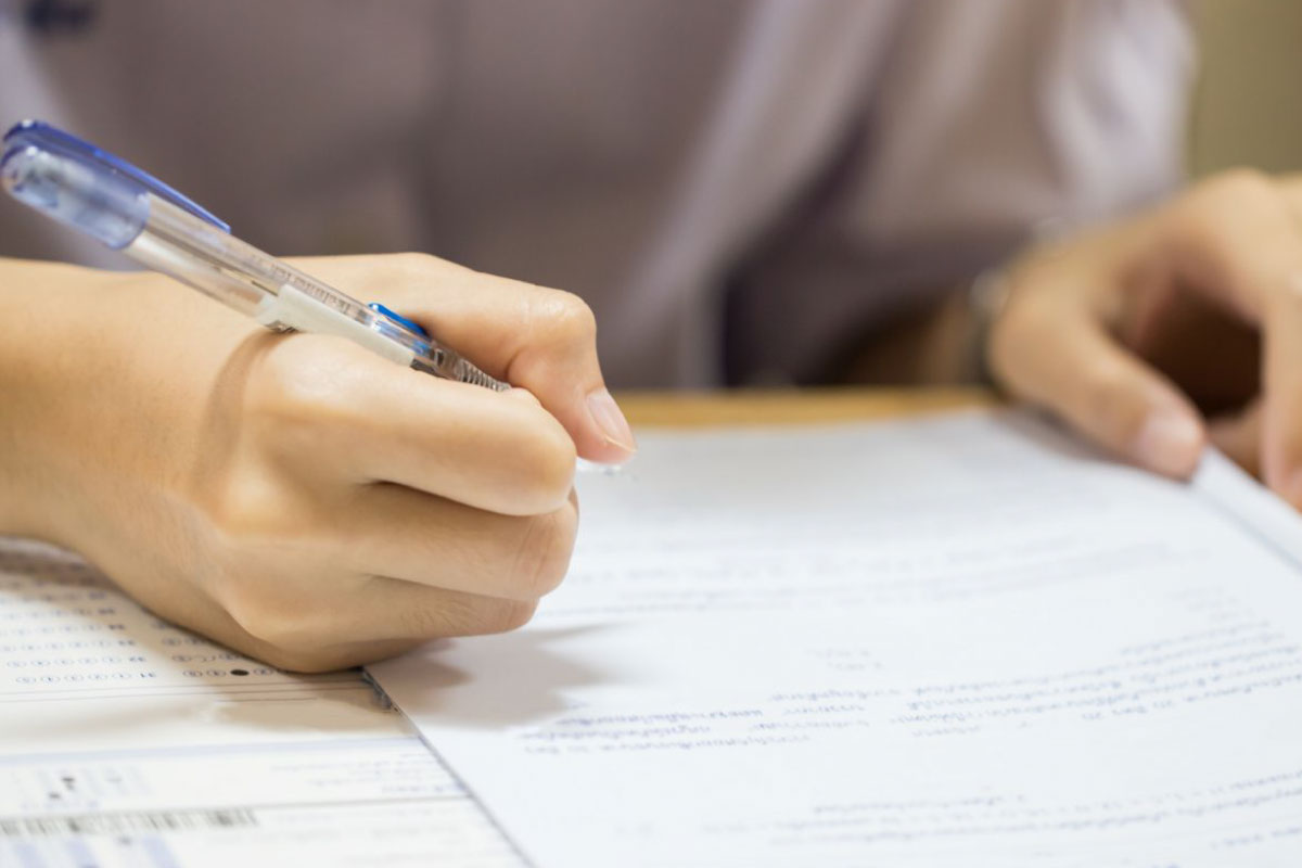 Acercamiento de las manos de una persona resolviendo una prueba.