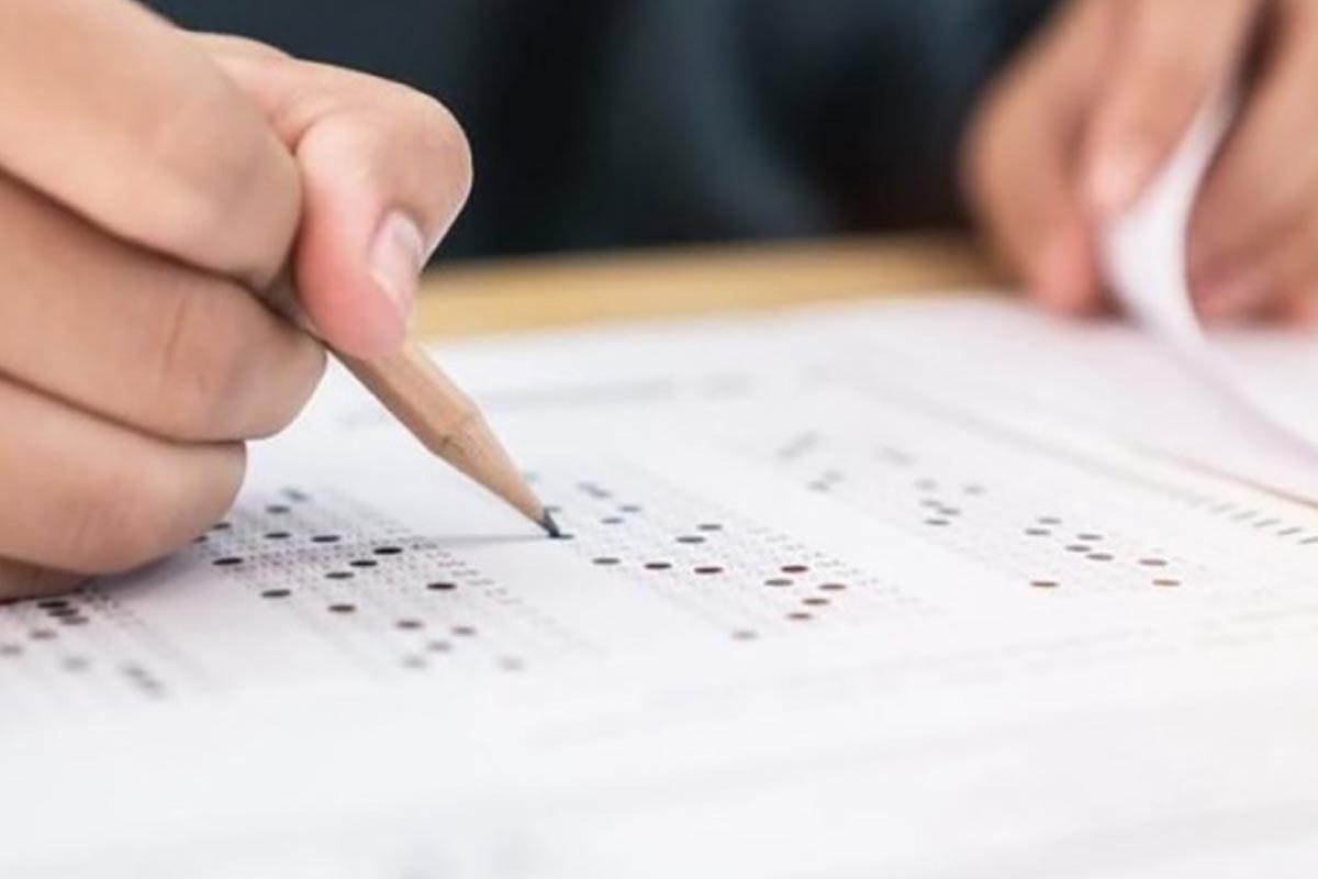 Persona llenando la hoja de respuestas de una prueba de múltiples opciones