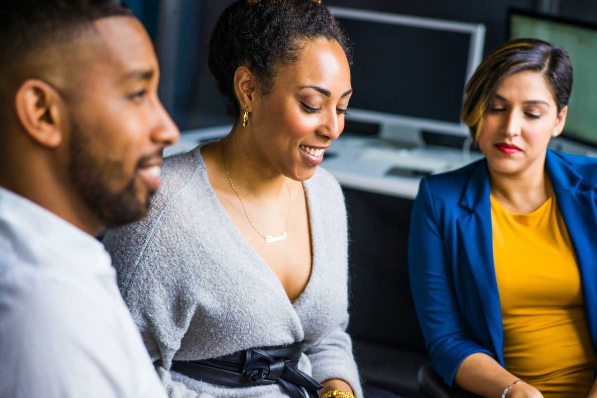 Tres personas en una oficina mirando notas.