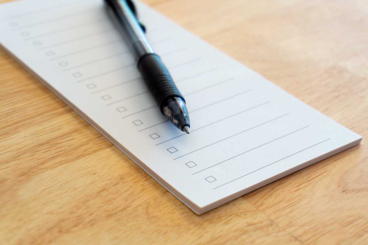 Libreta para listas con un lapicero encima.