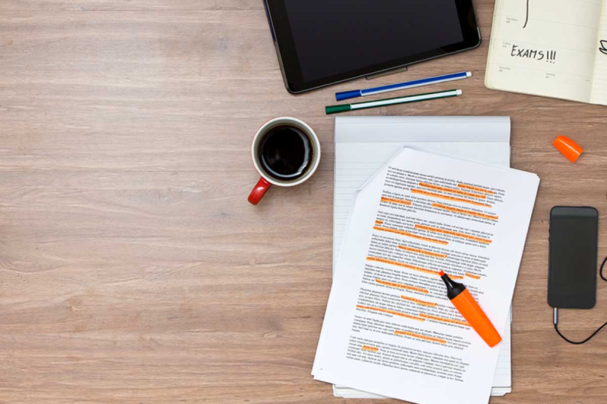 Impresión de notas sobre un escritorio, en donde se resaltan oraciones con marcador naranja