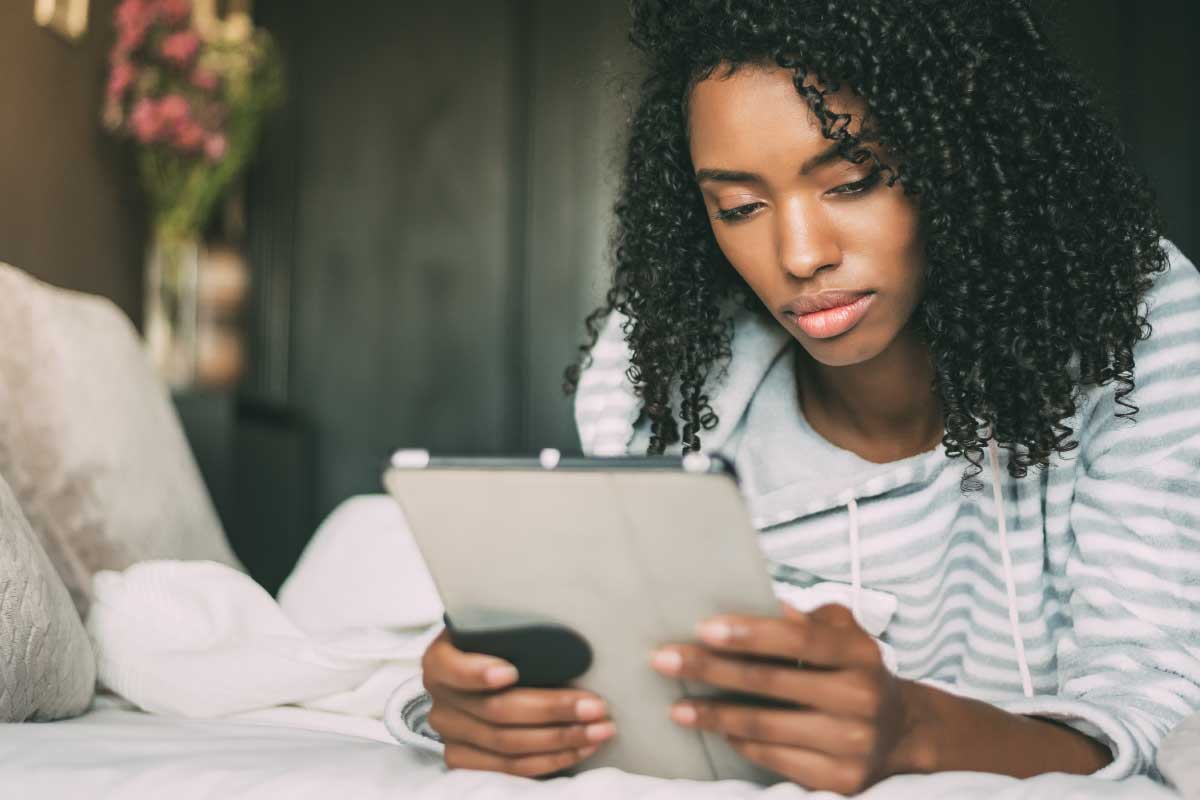 Mujer joven sentada mirando una tableta