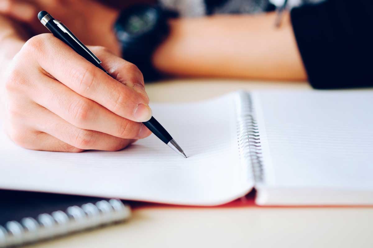 Acercamiento de una mano escribiendo en un cuaderno