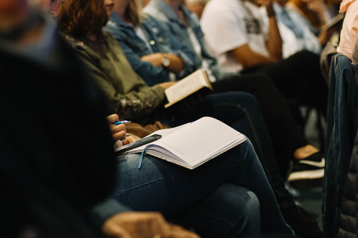 Grupo de estudiantes técnicos, sentados escuchando una clase y tomando nota
