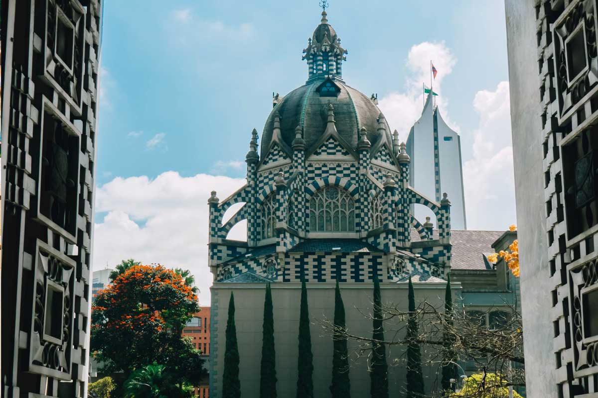 Primer plano parque público de Medellín, Antioquia, en el fondo, torre del Palacio de la Cultura en