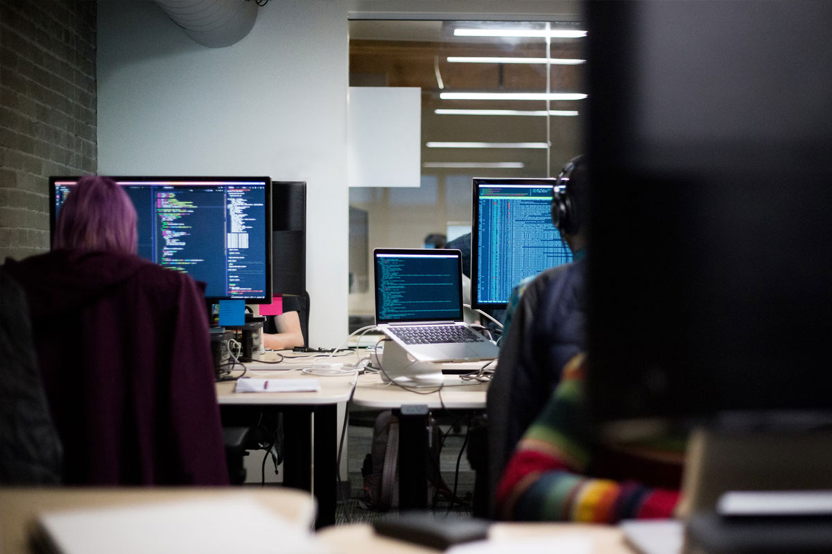 Grupo de estudiantes en sala de computadores, programando